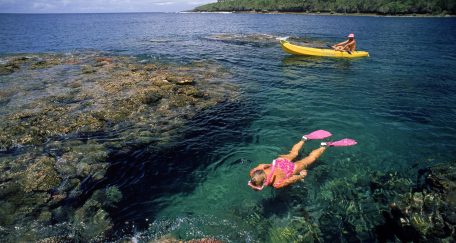 person floating at top of water and snorkeling