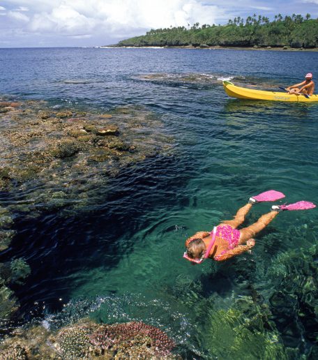 person floating at top of water and snorkeling