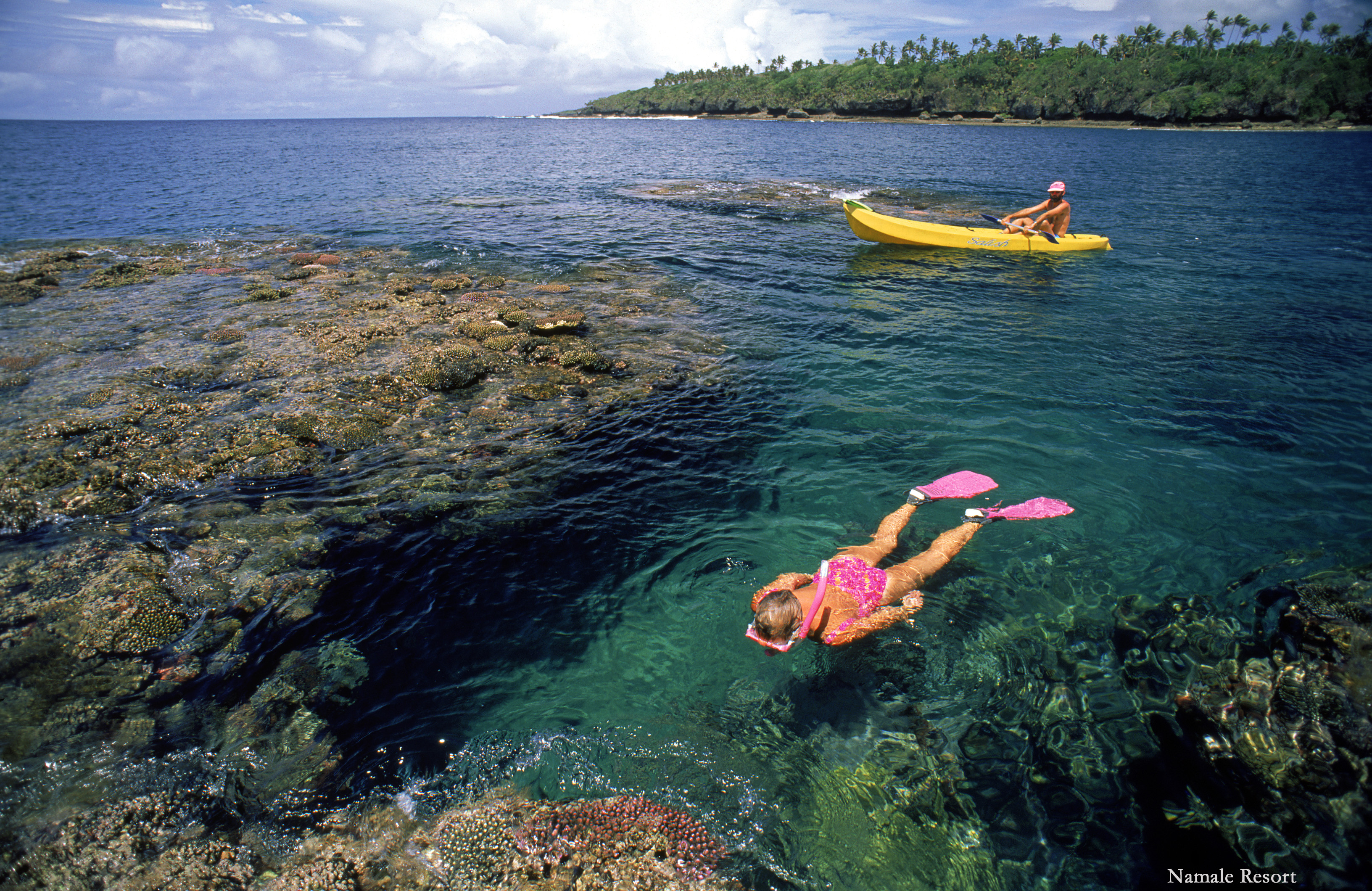 person floating at top of water and snorkeling
